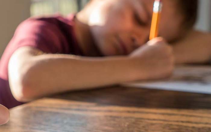 Young boy writing with pencil